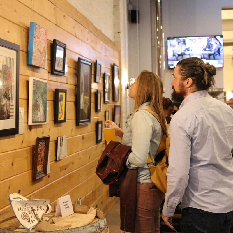 A photo of two people looking at art during an art exhibit.