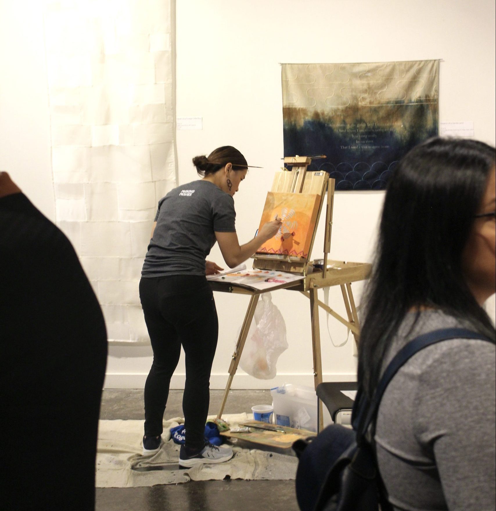 Artist works on live painting at NAAAP-KC's residency exhibition at The ArtsKC Gallery