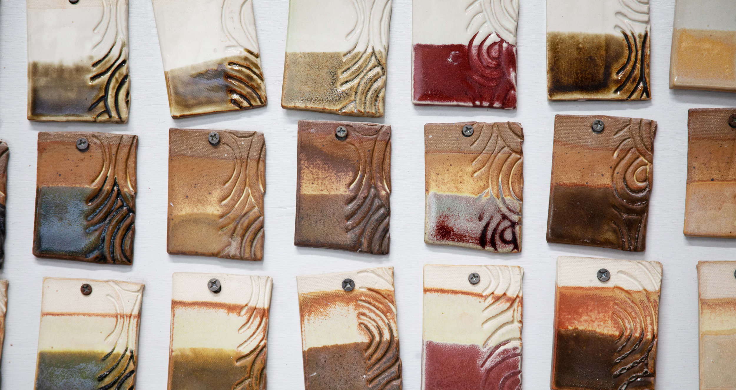Glaze test firing tiles hung up on wall