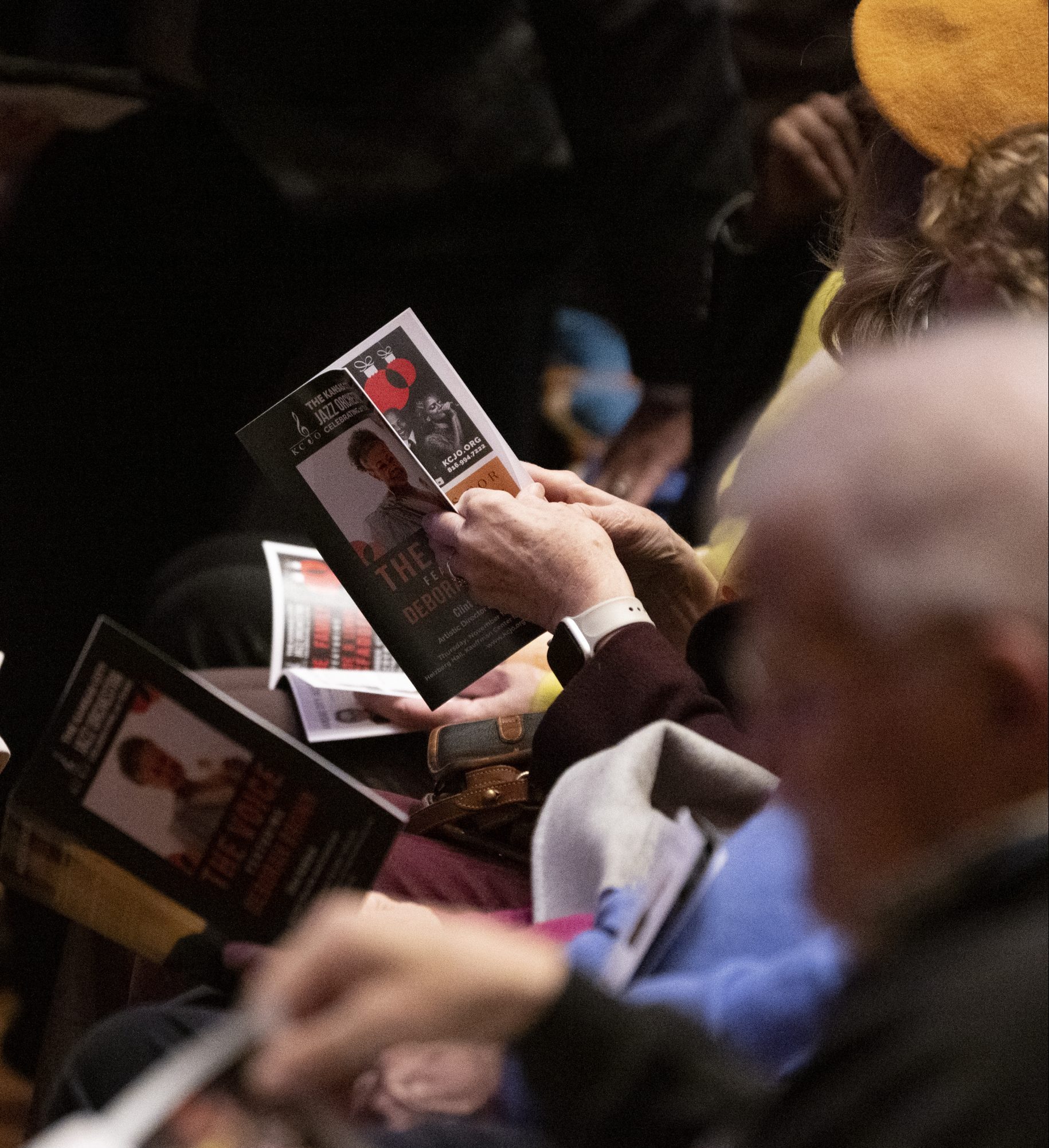 Audience members look through their event program